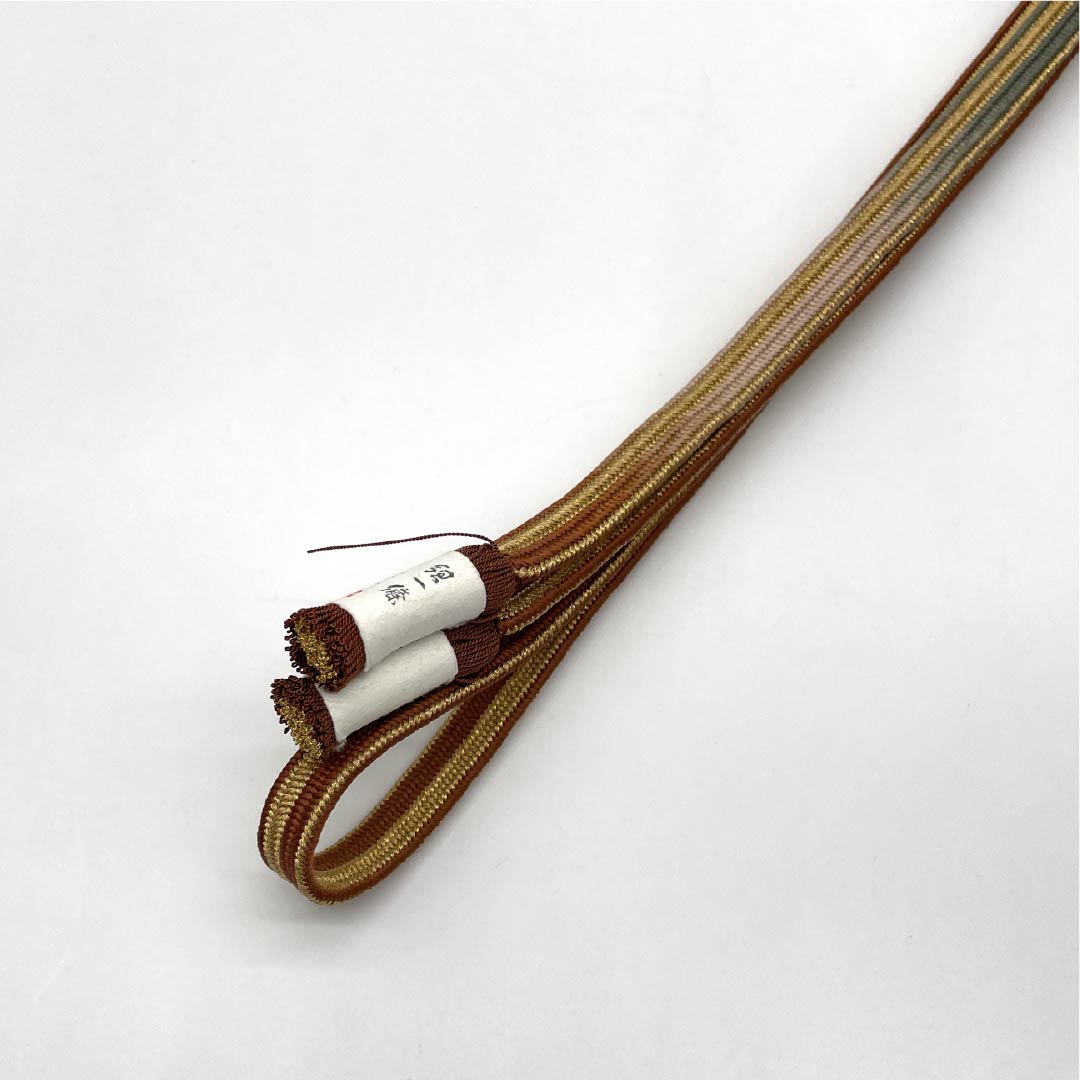 (Brand New) Pure Silk Obi-jime (Sash Band) in Dark Persimmon (Koi-gaki-iro) with Hirata Kumihimo Kainokuchi Striped Yugen Dyeing and Twisted Tassels. Approximately 160cm Long, 1.5cm Wide. Semi-Formal. Brown. Product Number: 1135005151314